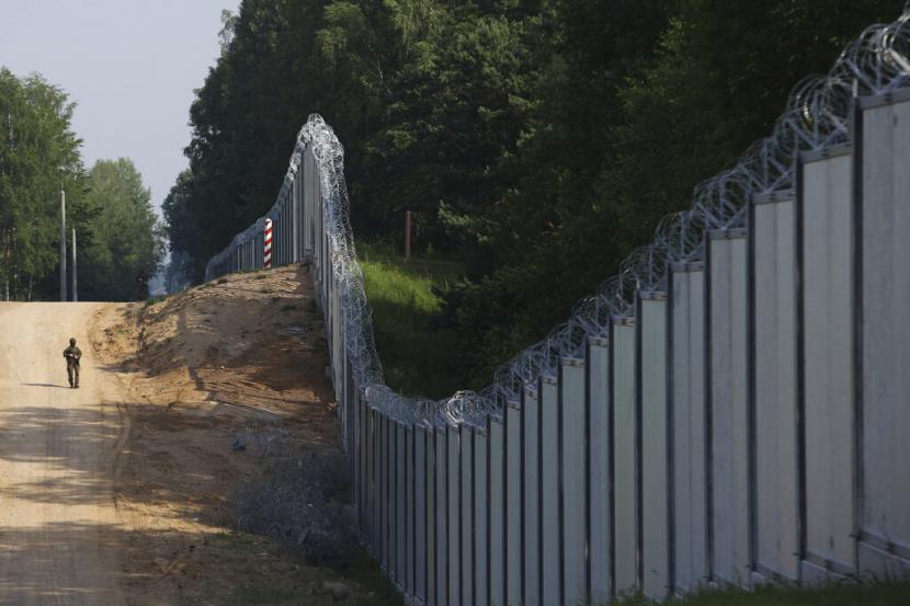 Penjaga perbatasan Polandia berpatroli di area tembok logam yang dibangun di perbatasan antara Polandia dan Belarusia, dekat Kuznice, Polandia, Kamis, 30 Juni 2022. 