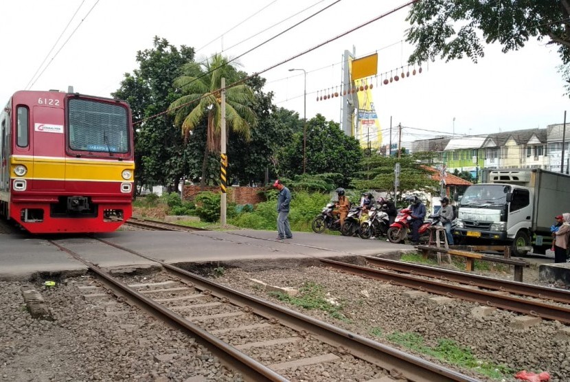 Penjaga perlintasan sebidang di Bulak Kapal, Kelurahan Aren Jaya, Bekasi Timur, Kota Bekasi, sedang menunggu kereta api melintas. Perlintasan sebidang tersebut merupakan satu dari dua perlintasan yang sampai saat ini tidak memiliki palang pintu di Kota Bekasi.