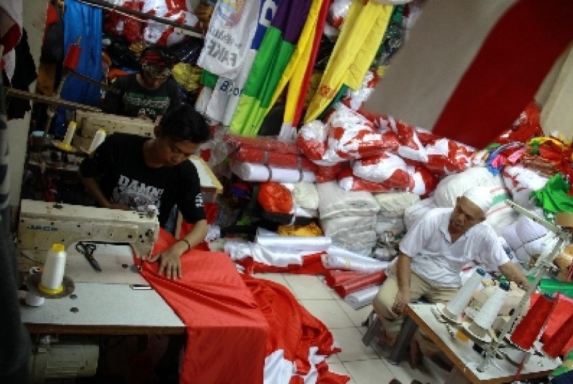 Penjahit menyelesaikan pesanan bendera merah putih di Blok V Pasar Senen, Jakarta