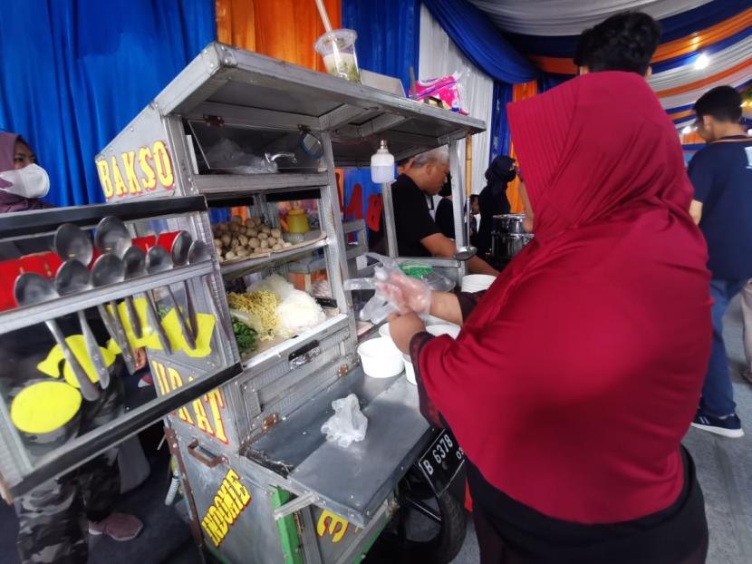 Penjual bakso Dewi Kusumawati menyiapkan hidangan bakso kepada para pelanggan.