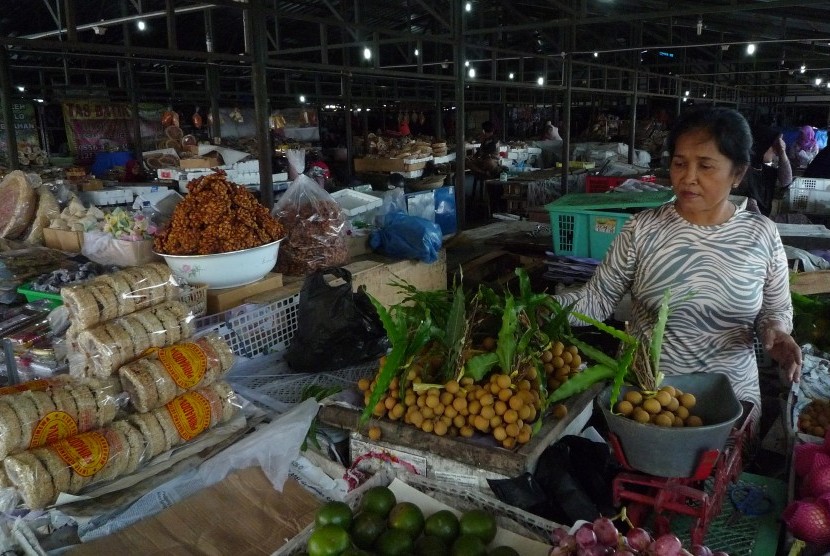 Penjual buah menimbang buah lengkeng di lokasi penampungan sementara pedagang Pasar Klewer di Solo, Jawa Tengah, Minggu (23/4).