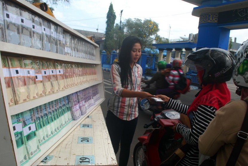 Penjual jasa penukaran uang melayani penukaran uang baru di depan Masjid Baitul Hakim, Kota Madiun, Jawa Timur. (ilustrasi)