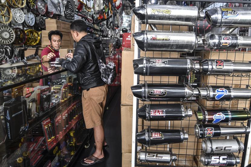 Penjual knalpot dan aksesori modifikasi sepeda motor melayani calon pembeli di kawasan Kampung Melayu, Jakarta, Jumat (19/3). Survei Bank Indonesia (BI) mengindikasikan penjualan eceran pada November 2021 kembali tumbuh.