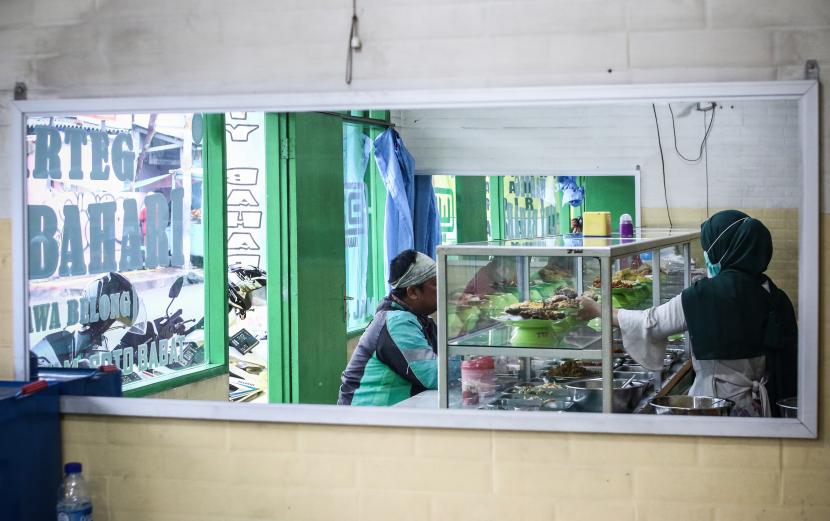 Penjual melayani pembeli di Warteg City Bahari, Rawa Belong, Jakarta, Ahad (24/1/2021). 