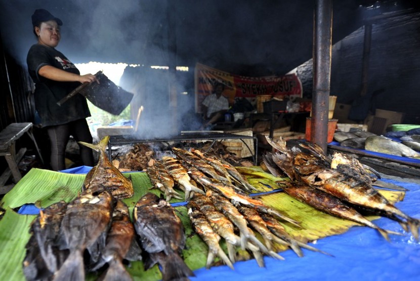 Penjual membakar ikan di Makassar, Sulsel.