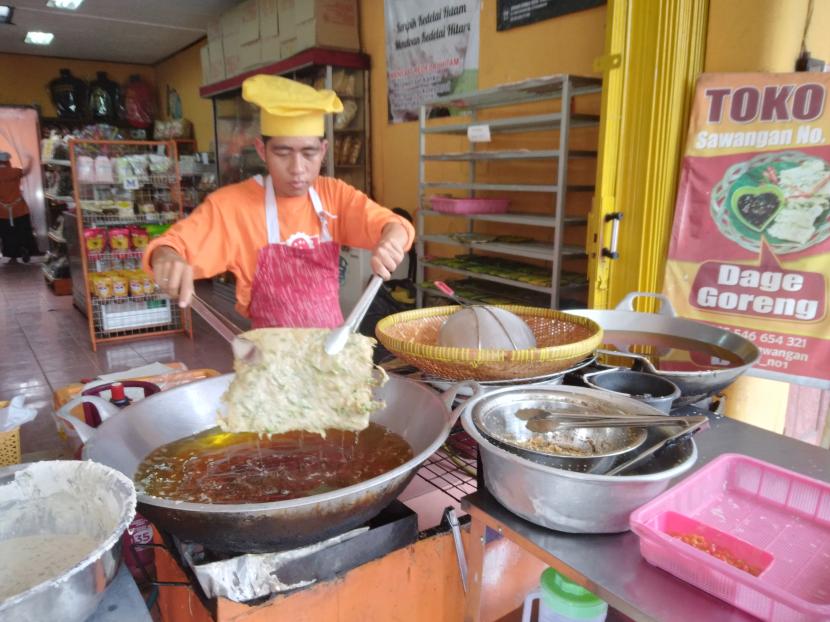 Penjual mendoan tengah menggoreng mendoan jumbo di sentra kuliner Sawangan, Purwokerto. 