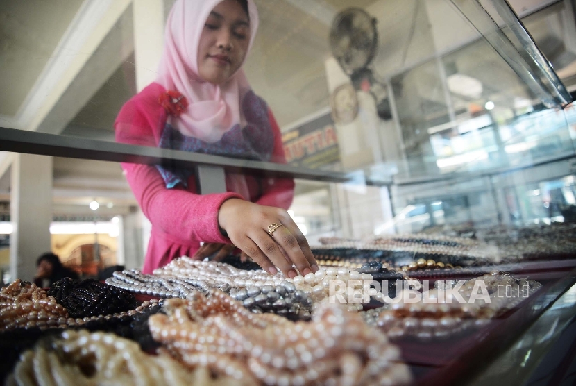 Penjual menunjukan perhiasan berupa mutiara air tawar yang dijual di sentra pusat perhiasan mutiara di Kawasan Sekarbela, Mataram, Nusa Tenggara Barat.