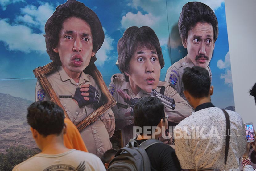 Penonton memperhatikan poster film Warkop DKI Reborn Part 1  pada acara BJB Wide Screen di Bekasi, Sabtu (10/9)