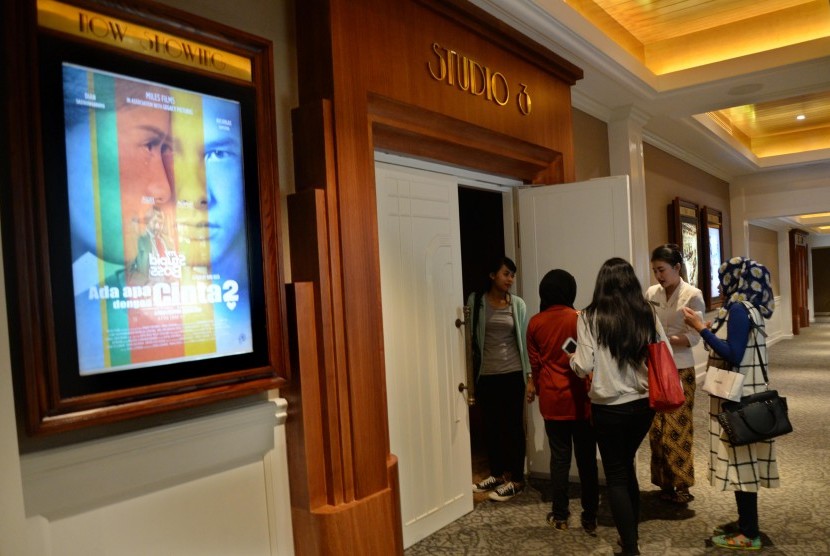 Penonton mengantre masuk ke studio bioskop di Jakarta.