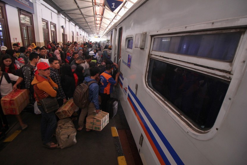 Penumpang antre masuk ke gerbong ereta api di Stasiun Gubeng Surabaya, Jawa Timur