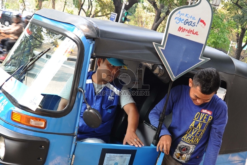 Penumpang bajaj biru turun di Jalan Medan Merdeka Utara, Jakarta Pusat, Selasa (18/8).