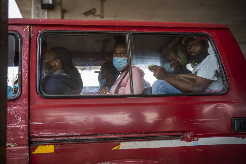 Penumpang, beberapa memakai masker, menunggu taksi mereka meninggalkan pangkalan taksi Baragwanath di Soweto, Afrika Selatan, Kamis 2 Desember 2021. Afrika Selatan meluncurkan kampanye vaksinasi yang dipercepat untuk memerangi peningkatan dramatis dalam kasus COVID-19 yang dikonfirmasi seminggu setelah varian omicron terdeteksi di negara tersebut.