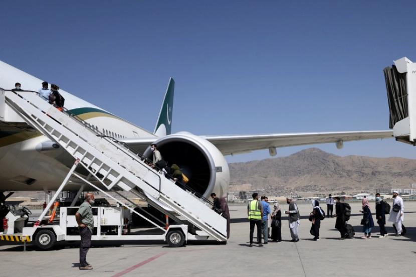 Penumpang berdiri dalam antrian untuk naik pesawat PIA, di bandara Kabul, Afghanistan. Taliban dan UEA Sepakati Kerja Sama Operasional Bandara di Afghanistan