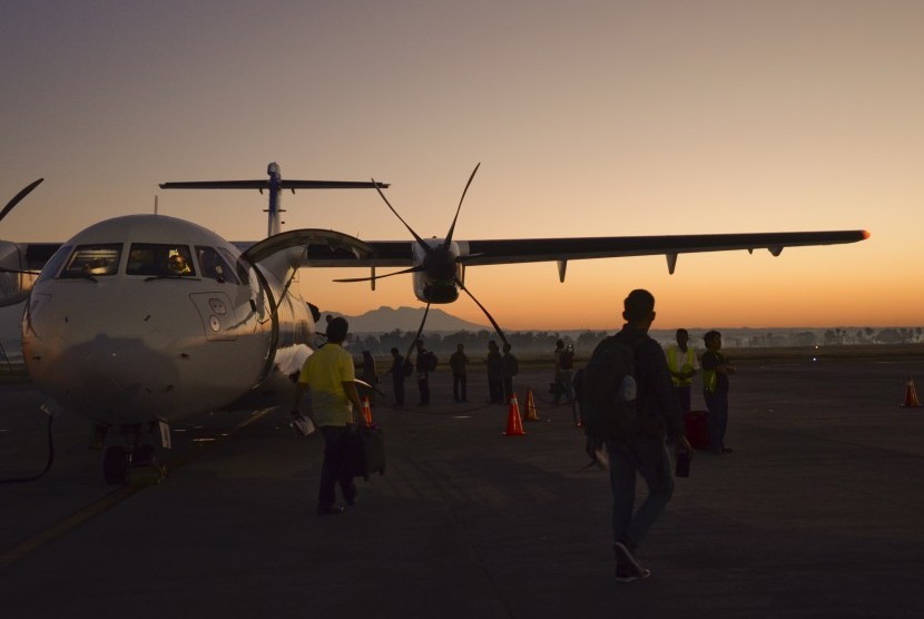Penumpang berjalan menuju pesawat di apron Bandara Lombok International Airport (LIA).