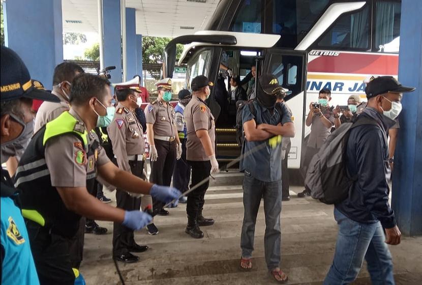 Penumpang bus dari wilayaj Jakarta dan Jawa Barat yang turun di terminal Bawen, Kabupaten Semarang, disemprot dengan cairan disinfektan, Jumat (27/3). 