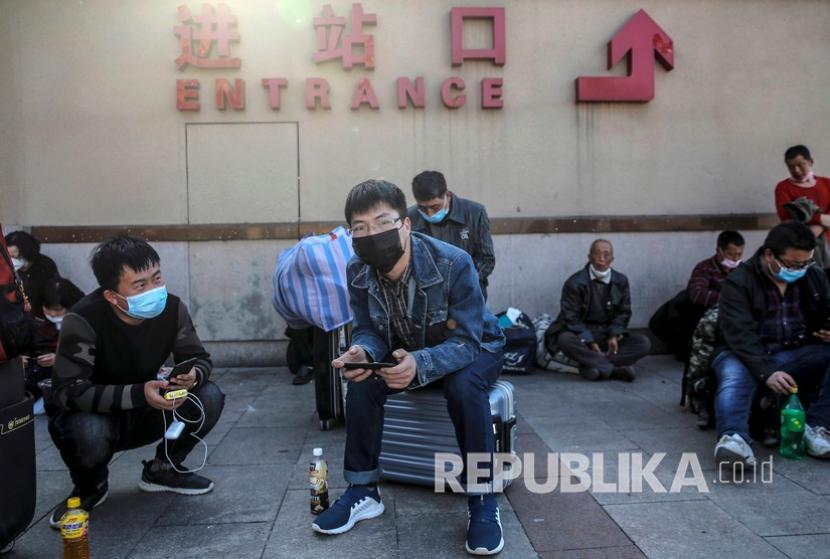 Penumpang dengan mengenakan masker menunggu di luar stasiun kereta api Beijing, China. Penyedia jasa layanan kereta api di China terpukul oleh lonjakan kasus Omicron. Ilustrasi.