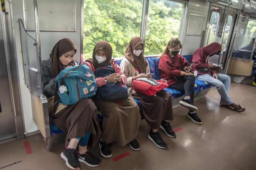 Penumpang duduk tanpa berjarak di dalam KRL Commuter Line, Jakarta, Rabu (9/3/2022). Pemerintah menerbitkan aturan baru naik KRL yaitu tempat duduk tanpa jarak, peningkatan kapasitas hingga 60 persen, balita dibolehkan naik dengan didampingi orang tua, wajib memakai masker, dilarang berbicara dan sudah divaksin COVID-19.