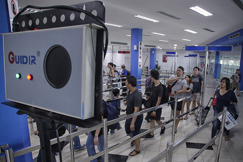 Penumpang kapal ferry dari Singapura melewati alat pendeteksi suhu tubuh (termal scaner) sebelum melakukan pengecapan paspor di terminal kedatangan Pelabuhan Internasional Batam Centre, Batam, Kepulauan Riau, Rabu (31/8).