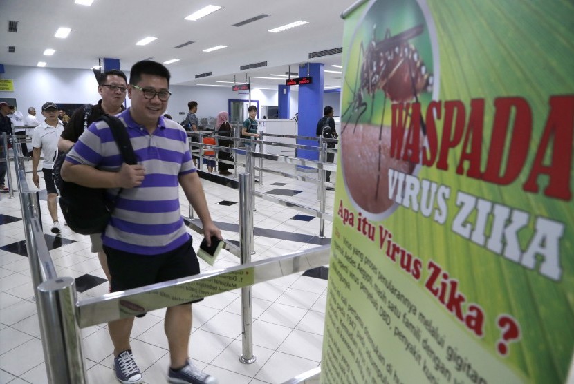 Penumpang kapal ferry dari Singapura melewati poster himbauan kewaspadaan terhadap penyebaran virus Zika di Pelabuhan Internasional Batam Centre, Batam, Kepulauan Riau, Kamis (1/9). 