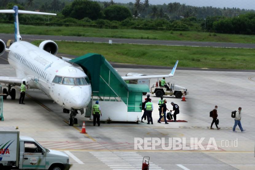 Penumpang keluar dari pesawat di Bandara Banyuwangi, Jawa Timur, Sabtu (16/5/2020). Setelah aktivitas penerbangan ditutup untuk menghindari penyebaran wabah COVID-19, mulai hari ini penerbangan kembali dibuka dengan menerapkan protokol pencegahan penularan COVID-19.