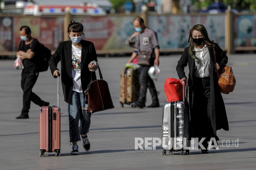 Penumpang kereta api dengan mengenakan masker berjalan di luar stasiun kereta api Beijing, Cina. Hingga kini, China telah mengonfirmasi 86.431 kasus Covid-19, dengan total kematian 4.634. Ilustrasi.