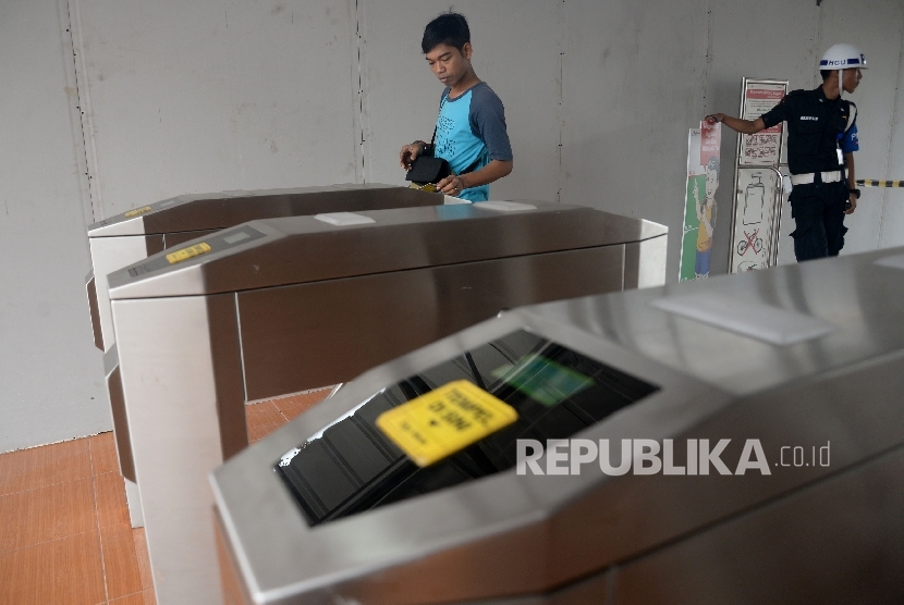  Penumpang kereta commuter line melewati pintu tiket elektronik di Stasiun Klender, Jakarta, Ahad (28/5).