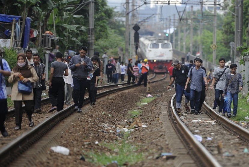 Penumpang Kereta Rel Listrik (KRL) dari Stasiun Cikini berjalan kaki menuju Stasiun Manggarai imbas anjloknya KRL rute Manggarai-Duri di antara lintasan Manggarai-Sudirman, Manggarai, Jakarta, Rabu (6/4).