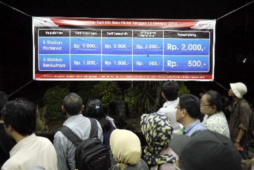 Penumpang KRL membaca pengumuman kenaikan tarif KRL Commuter Line di Stasiun Bekasi, Selasa (14/10).