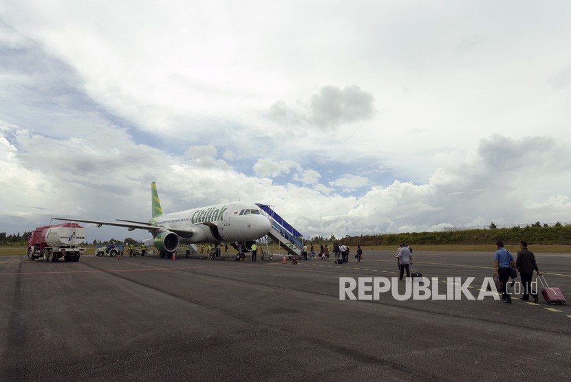 Penumpang maskapai Citilink dengan rute Silangit-Halim Perdanakusuma Jakarta bergegas memasuki pesawat di Bandara Internasional Silangit, Tapanuli Utara, Sumut, Senin (11/12).
