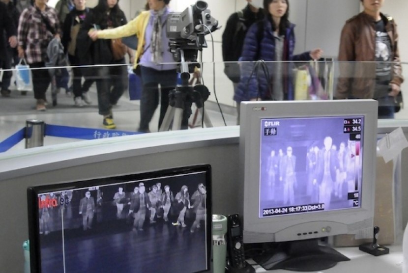 Penumpang melewati detektor temperatur tubuh di Bandara Internasional Taoyuan, Selatan Taiwan. Ini sebagai salah satu langkah untuk mendeteksi gejala flu burung