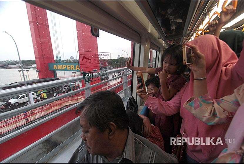 Penumpang melihat Jembatan Ampera dari dalam gerbong kereta Api Ringan atau Light Rapid Transit (LRT) ketika menuju Jakabaring, Palembang, Sumatera Selatan, Selasa (28/8). 