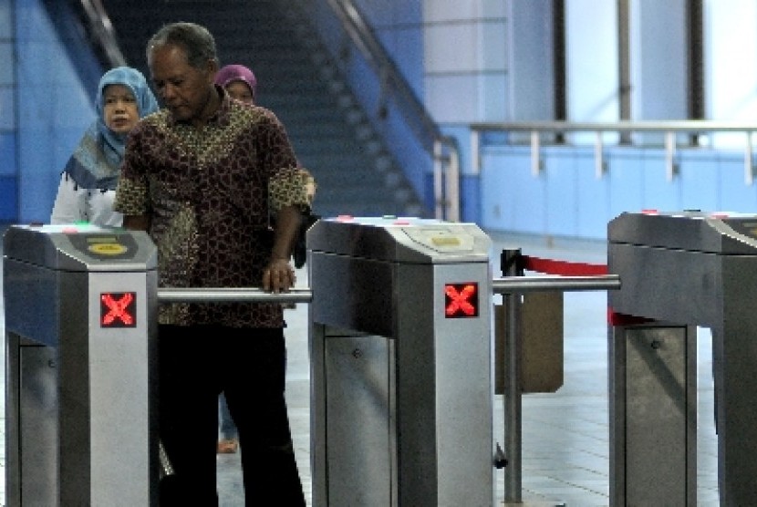 Penumpang melintasi pintu tiket elektronik Kereta Rel Listrik (KRL) saat tiba di Stasiun Juanda, Jakarta, Senin (19/8).