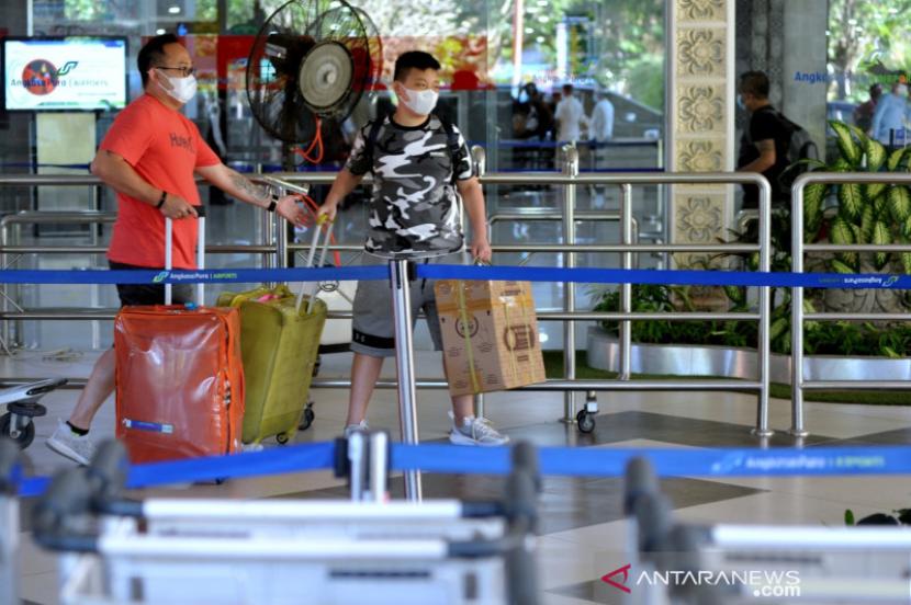 Penumpang membawa barang bawaan di Bandar Udara Internasional I Gusti Ngurah Rai, Bali. 