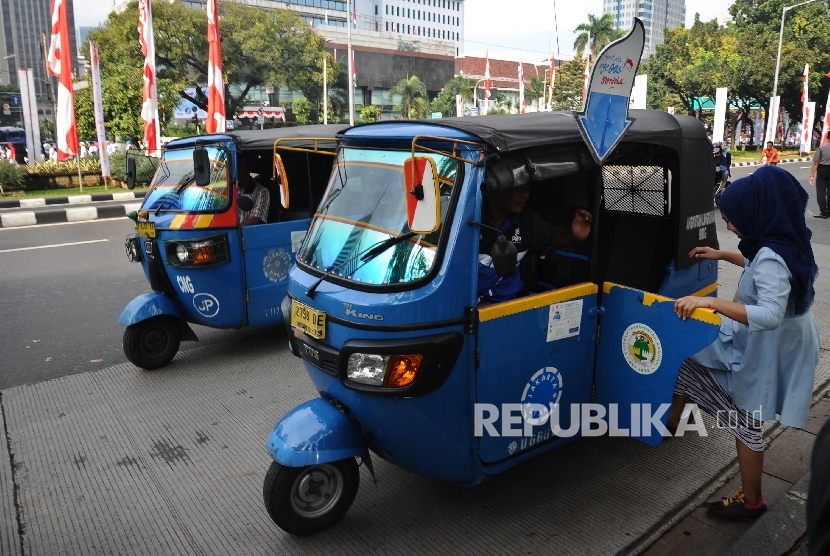 Penumpang menaiki bajaj gas seusai pelepasan 700 bajaj gas gratis di Mobile Refueling Unit (MRU) PGN Station IRTI Monas, Jakarta, Ahad (14/8). 