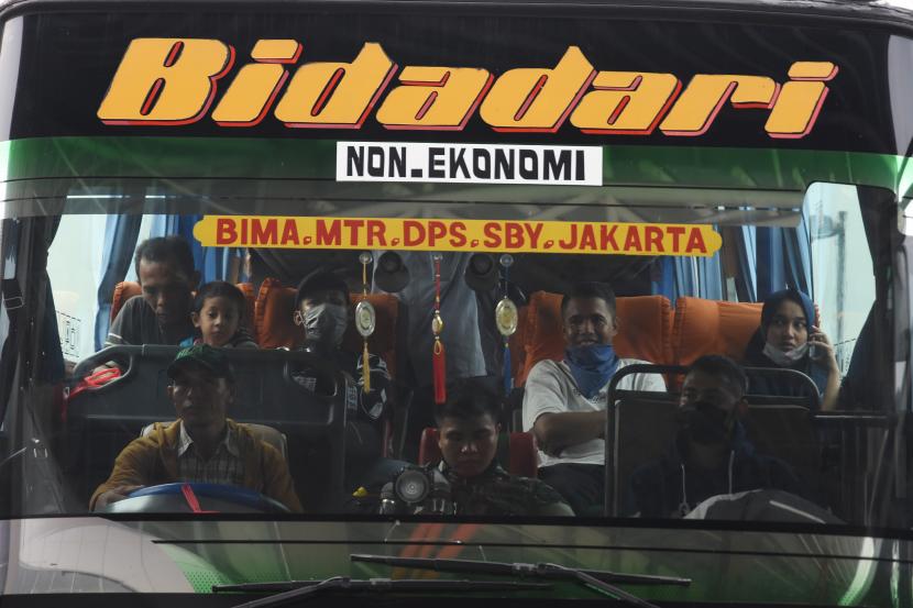 Penumpang menaiki bus Antar Kota Antar Provinsi di Terminal Pulo Gebang, Jakarta, Ahad (29/3/2020). Kementerian Perhubungan mengimbau agar warga membatalkan niatnya pulang kampung, untuk mencegah penyebaran COVID-19. 
