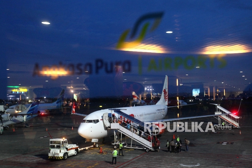 Penumpang menaiki maskapai di teminal keberangkatan Bandara Ngurah Rai, Bali.