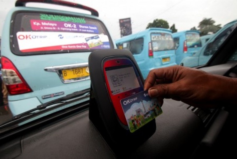 Penumpang menempelkan kartu Ok-Otrip saat menaiki angkutan umum jurusan Kampung Melayu-Duren Sawit di Terminal Kampung Melayu, Jakarta, Senin (15/1). 