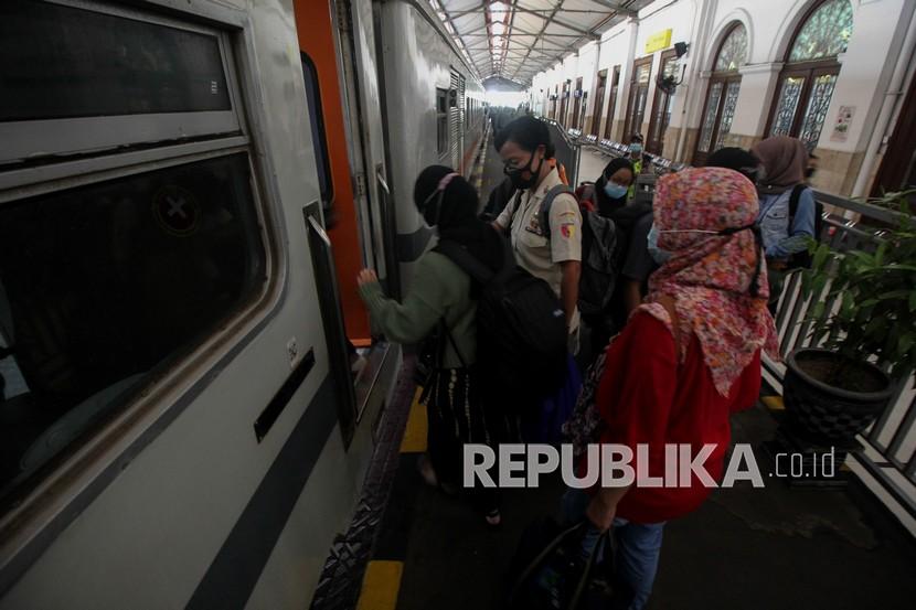 Penumpang mengantre untuk naik ke kereta api di Stasiun Gubeng Surabaya, Jawa Timur.