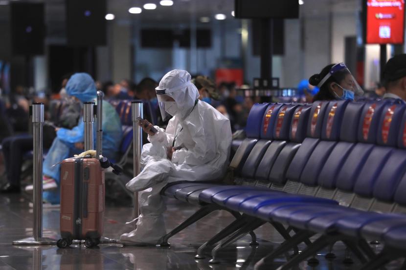 Penumpang menggunakan telepon saat menunggu untuk naik pesawat di bandara Tan Son Nhat di kota Ho Chi Minh, Vietnam, Jumat, 15 Oktober 2021. Polisi Vietnam menangkap Wakil Luar Negeri To Anh Dung. 