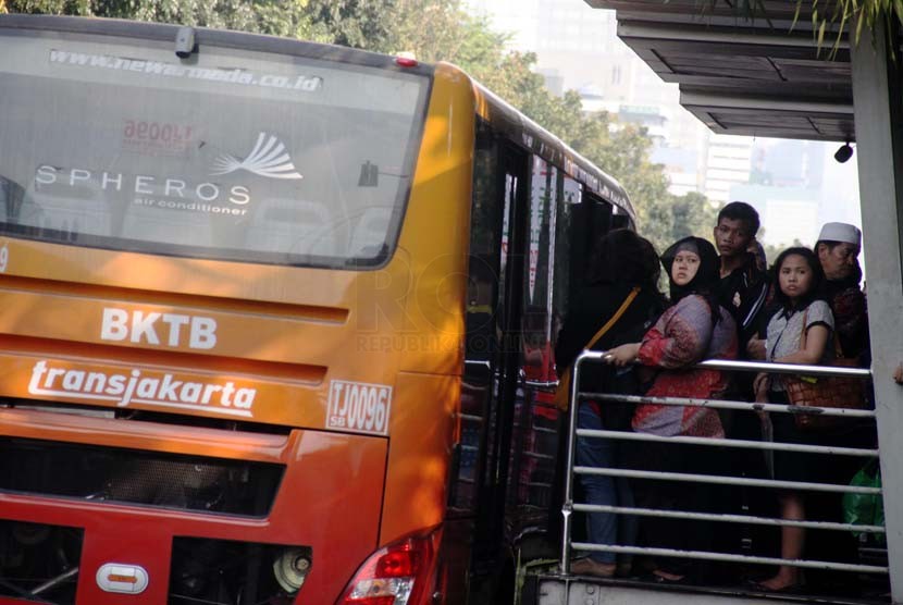 Penumpang menunggu Bus TransJakarta di Halte Bus Monumen Nasional, Jakarta Pusat, Jumat (20/6). 