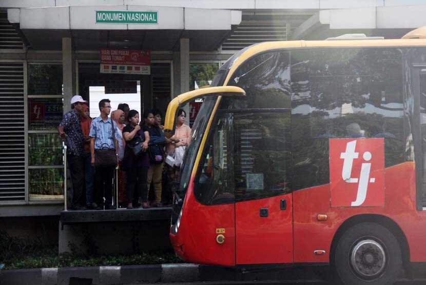 Penumpang menunggu Bus TransJakarta di Halte Bus Monumen Nasional, Jakarta Pusat, Jumat (20/6). 