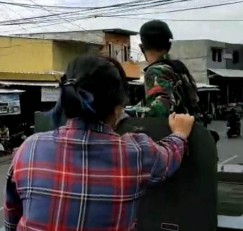 Penumpang perempuan warga sipil memakai baju kotak-kotak naik panser TNI yang ditugaskan mencopot spanduk dan baliho HRS di berbagai titik di Jakarta, Jumat (21/1).