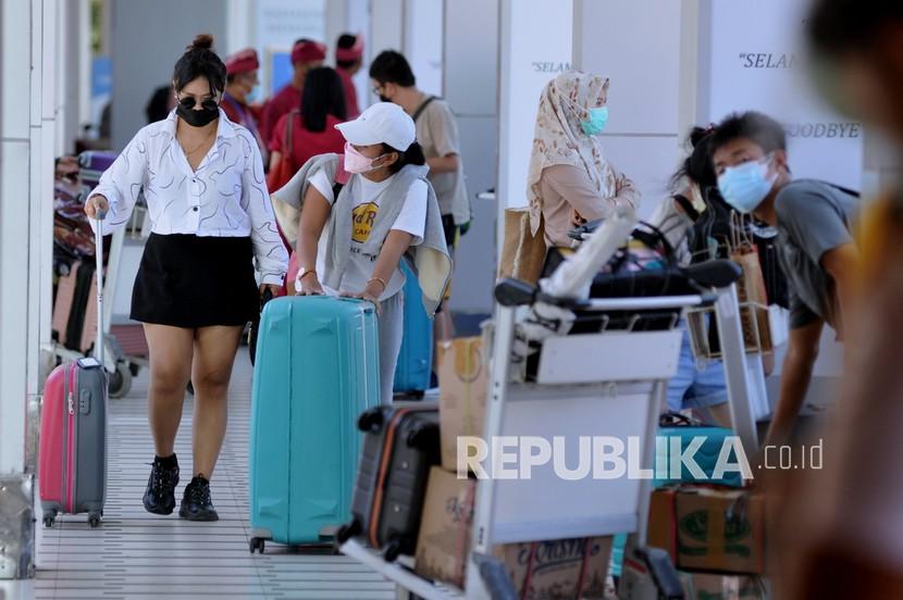 Penumpang pesawat membawa barang bawaan di Terminal Domestik Bandara Internasional I Gusti Ngurah Rai, Badung, Bali, Selasa (29/6). Pemerintah memperpanjang masa pemberlakuan pembatasan kegiatan masyarakat (PPKM) di dalam dan luar Jawa-Bali hingga 4 Oktober 2021.
