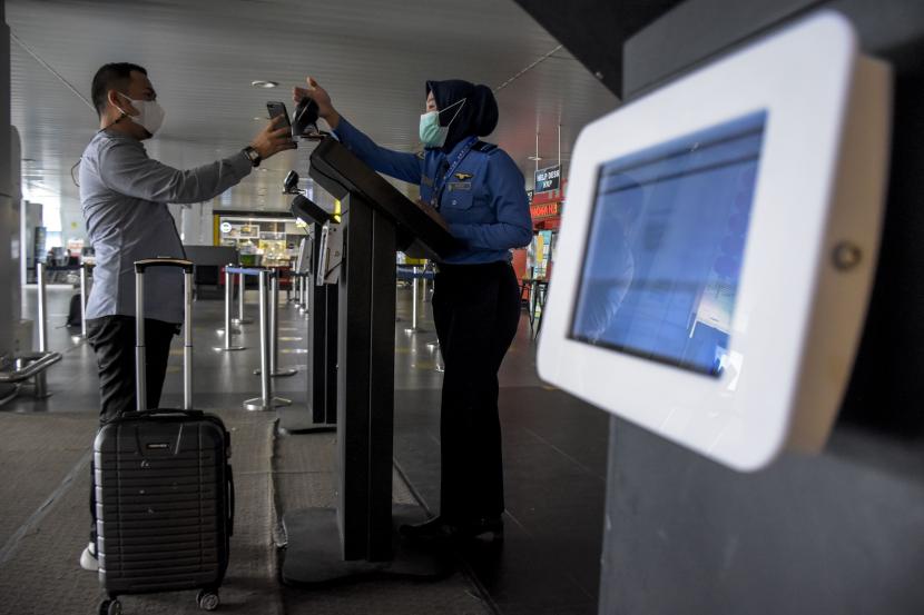 Penumpang pesawat terbang menunjukkan e-Hac (electronic-Health Alert Card) di aplikasi Peduli Lindungi kepada petugas sebelum keberangkatan di Bandara Husein Sastranegara, Kota Bandung.