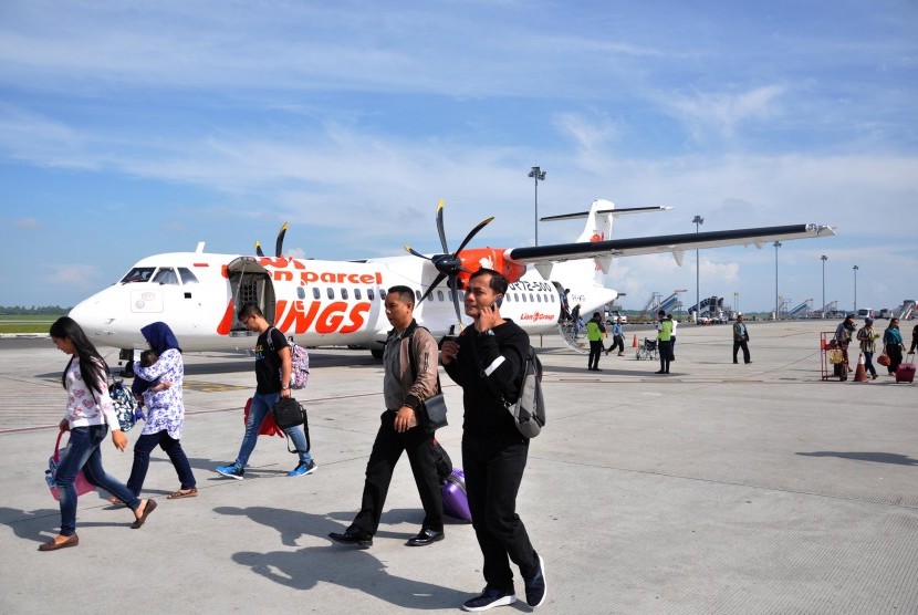 Penumpang pesawat udara berjalan menuju terminal kedatangan saat tiba di Bandara Internasional Kualanamu, Kabupaten Deli Serdang, Sumatera Utara, Senin (14/1).  Sejumlah maskapai penumpang telah menginformasikan pengajuan penerbangan tambahan untuk penerbangan kargo di sejumlah bandara AP II. 