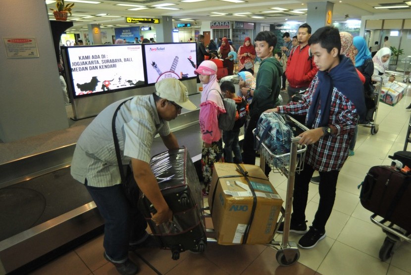 Penumpang pesawat udara mengemasi barang bagasi mereka setibanya di Bandara Internasional Minangkabau (BIM), Padangpariaman, Sumatra Barat. 