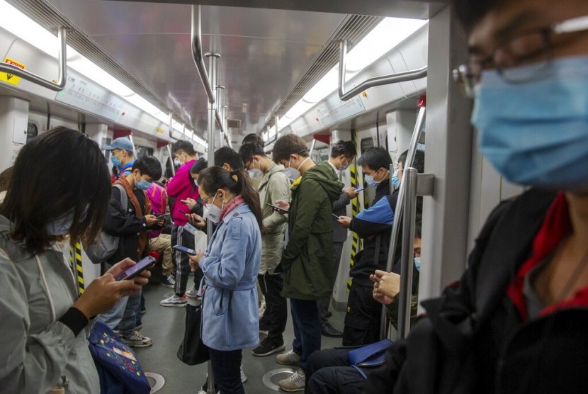 Penumpang sibuk dengan ponsel masing-masing dalam sebuah perjalanan kereta di Kota Guangzhou, Provinsi Guangdong, China, Senin (10/2). Provinsi Guangdong menjadi satu dari empat provinsi lain di China yang menurunkan level darurat corona.