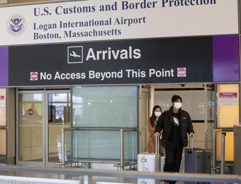 Penumpang tiba di Bandara Internasional Logan di Boston, AS. CDC Sarankan pertemuan di atas 50 orang dibatalkan demi cegah penyebaran virus corona. Ilustrasi.