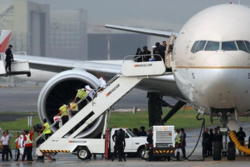 Penumpang turun dari pesawat Saudi Arabian Airlines yang diparkir di Bandara Internasional Ninoy Aquino di Manila, Filipina menyusul alarm pembajakan palsu, Selasa (20/9).