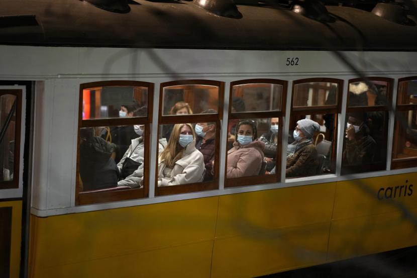 Penumpang yang memakai masker naik trem di Lisbon, pada 17 Desember 2021. Pada 31 Desember 2021, Portugal mencatatkan rekor baru kasus harian Covid-19 yang didominasi varian Omicron. 